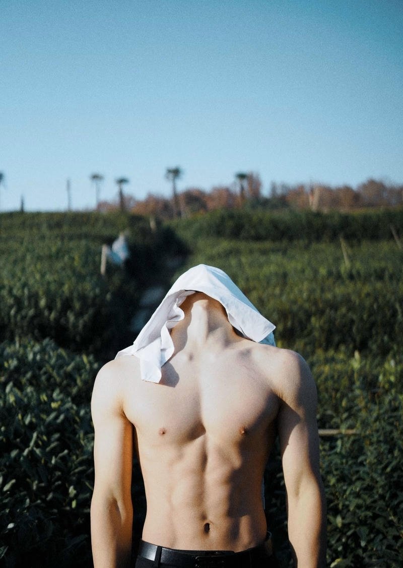 Thân hình thể thao nam mẫu tạo dáng che mặt bí ẩn